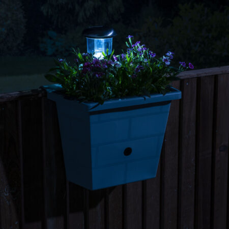 Solar fence planter and bird box illuminated at night